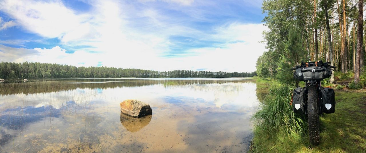 Järvimaisema ja retkipyörä järven rannalla.