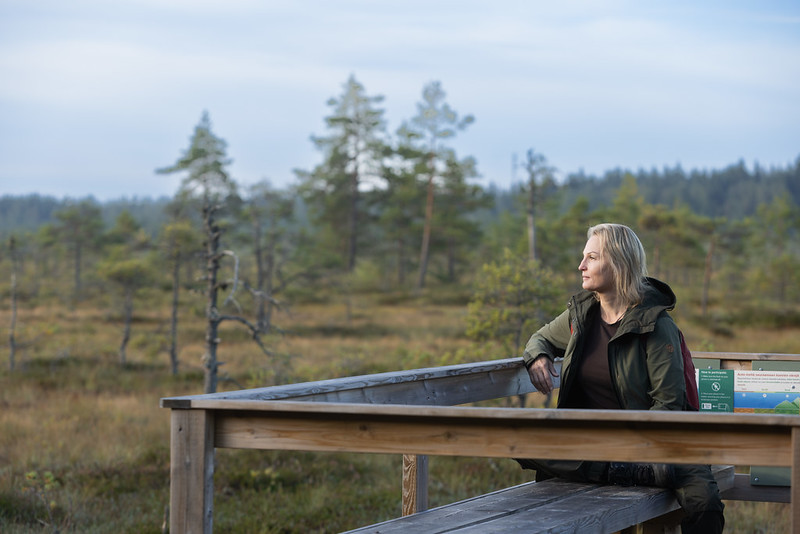 Nainen istuu ja katsoo suolle.