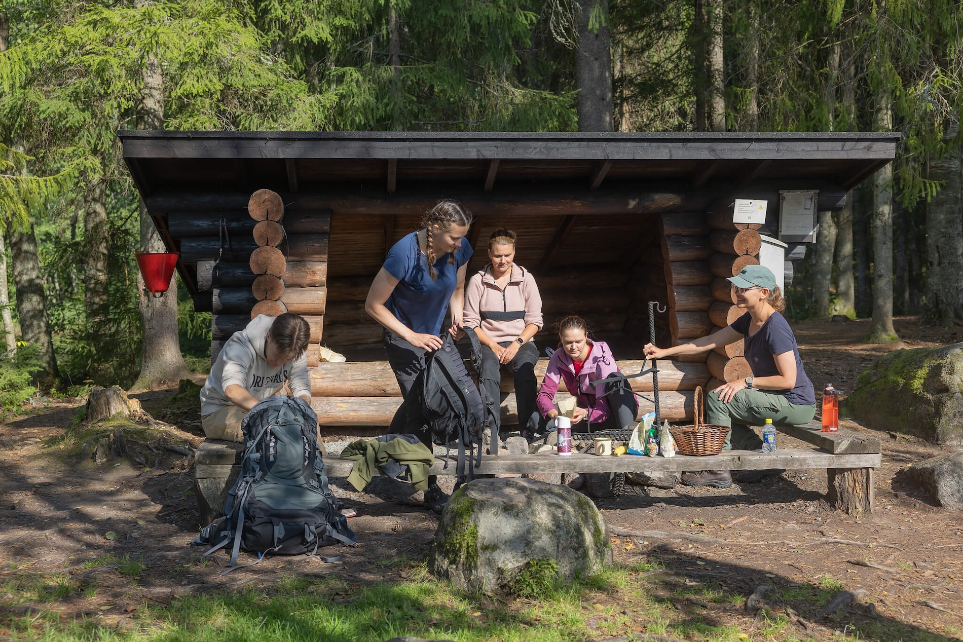 Ihmiset ovat pysähtyneet rekellä pitämään taukoa ja syömään laavulle.