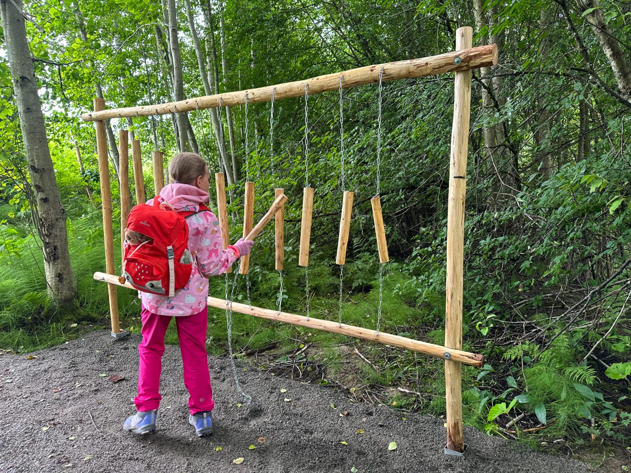 Lapsi soittaa metsässä puista ksylofonia.